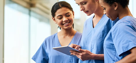 group of female healthcare professionals looking at tablet